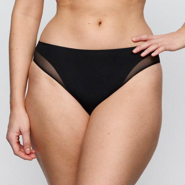 Person wearing black underwear on a plain background