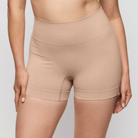 Beige shapewear shorts worn by a person on a plain background