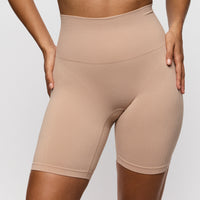 Beige high-waisted shorts worn by a person on a light gray background