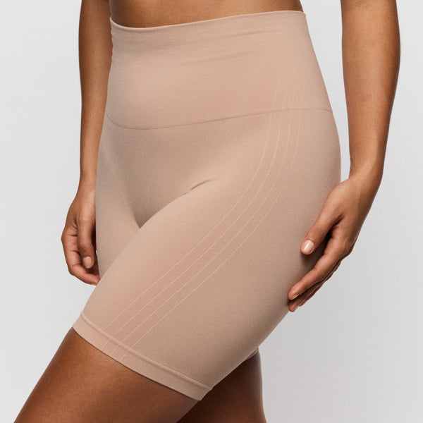 Beige shapewear shorts worn by a person on a plain background