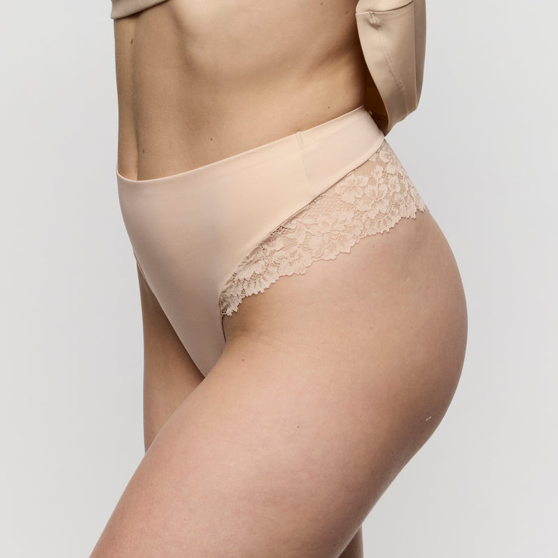 Beige lace-trimmed underwear on a mannequin against a plain background