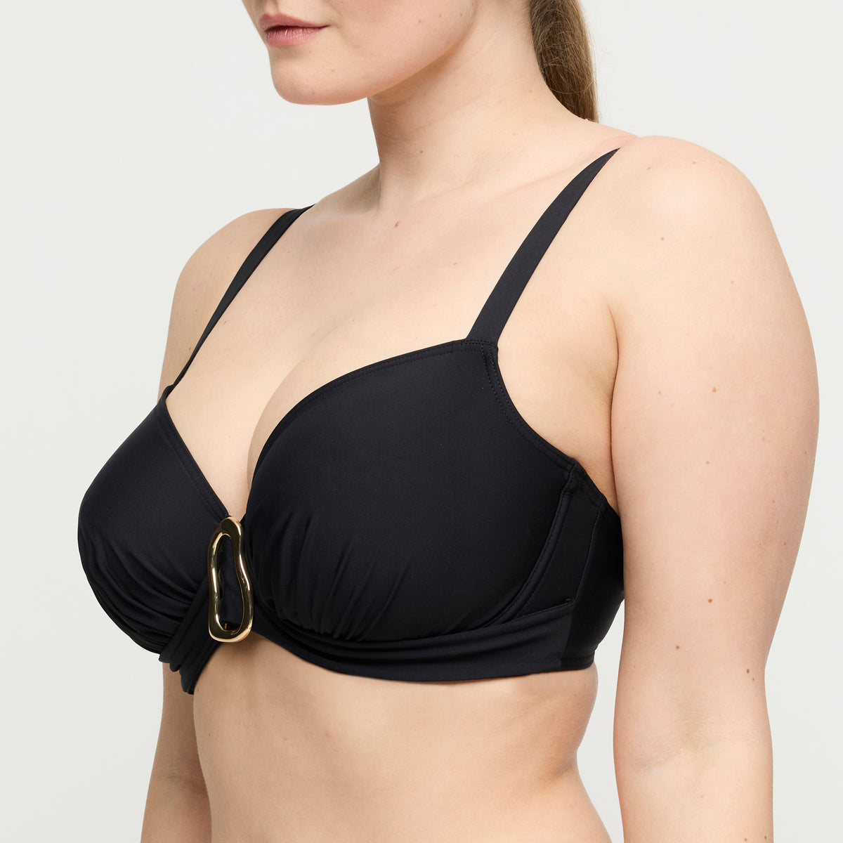 Black bikini top with a gold clasp on a plain background