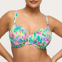 Colorful tie-dye bikini top worn by a model on a light gray background