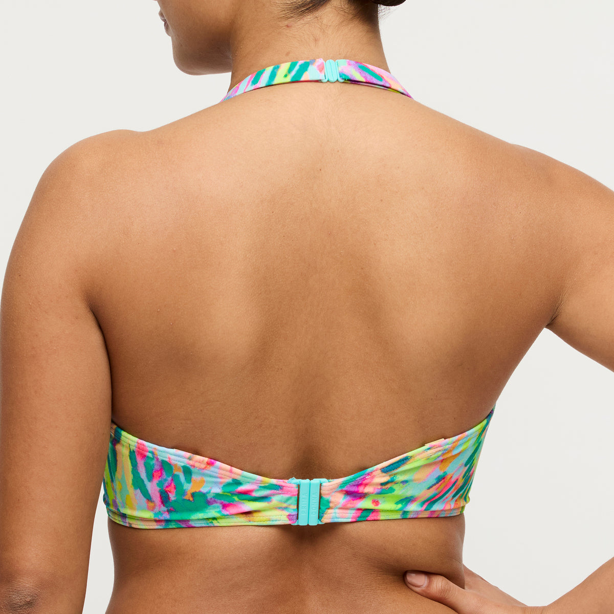 Multicolored bikini top worn by a person on a plain background