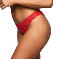 A close-up of a model wearing bright red lace panties against a plain white background.