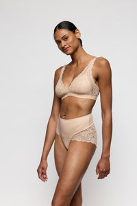 Woman wearing a beige lingerie set on a white background