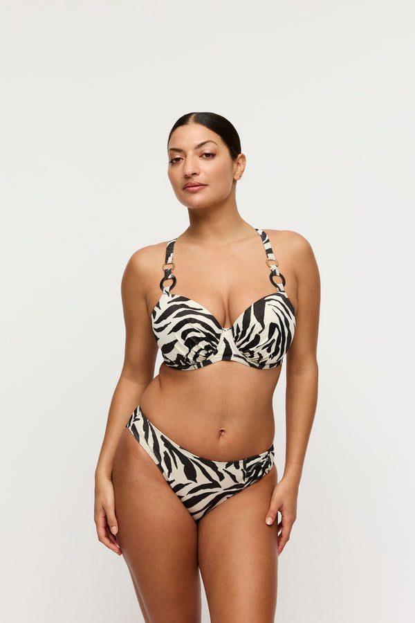 Woman wearing a zebra print bikini on a plain background