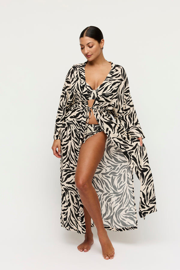 Woman wearing a zebra print robe on a white background