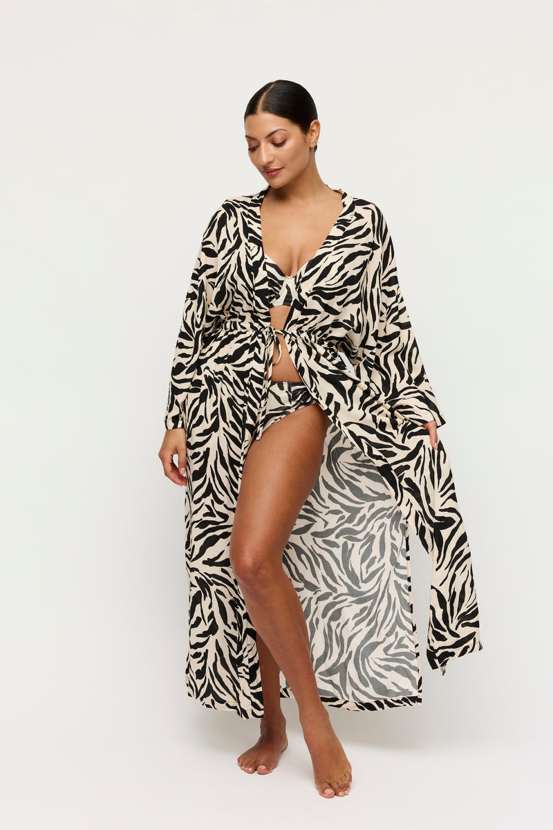 Woman wearing a zebra print robe on a white background