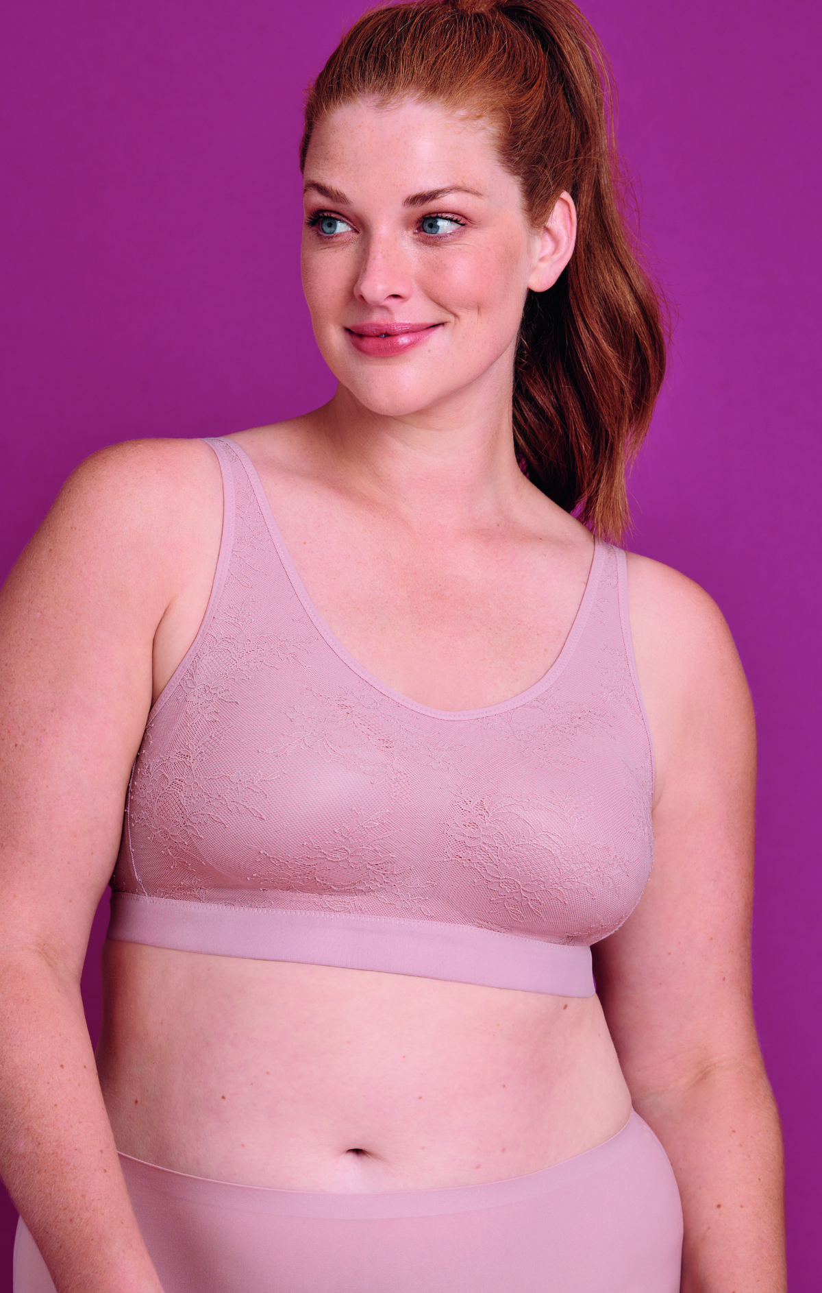 Woman wearing a light purple wireless bra against a purple background